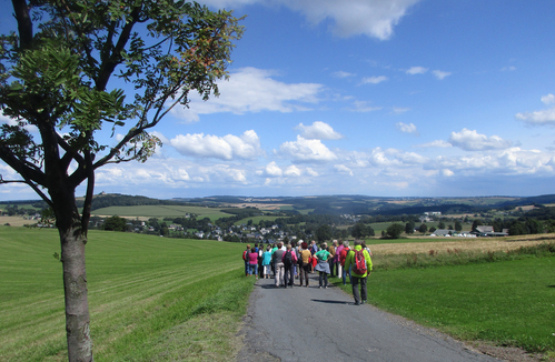 einzelne Menschen auf Wanderweg mit Kirchturm am Horizont - Auf Wanderwegen unser Gemeindegebiet entdecken -  (Foto: © Wanderfreunde Triebeltal)